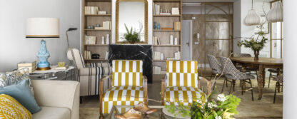 Salón con sofá beige, sillones tapizados en mostaza y blanco, cojines decorativos y cuadro abstracto en vivienda familiar de Algorta