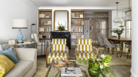 Salón con sofá beige, sillones tapizados en mostaza y blanco, cojines decorativos y cuadro abstracto en vivienda familiar de Algorta