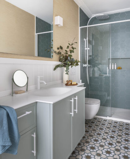 Baño juvenil con muebles verdes, suelo hidráulico, ducha con cerámica hexagonal y detalles naturales en proyecto de interiorismo en Getxo